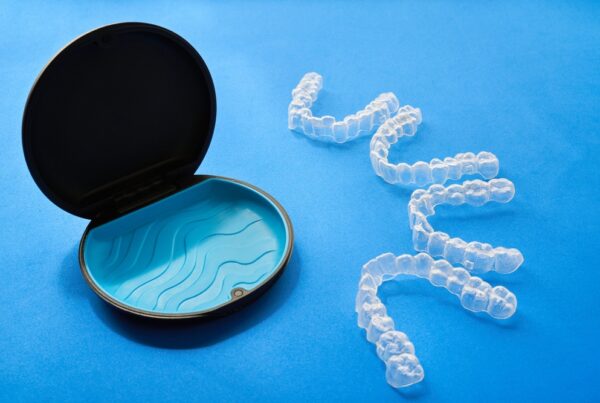 A small plastic case containing a toothbrush and a tube of toothpaste, designed for travel or personal hygiene.